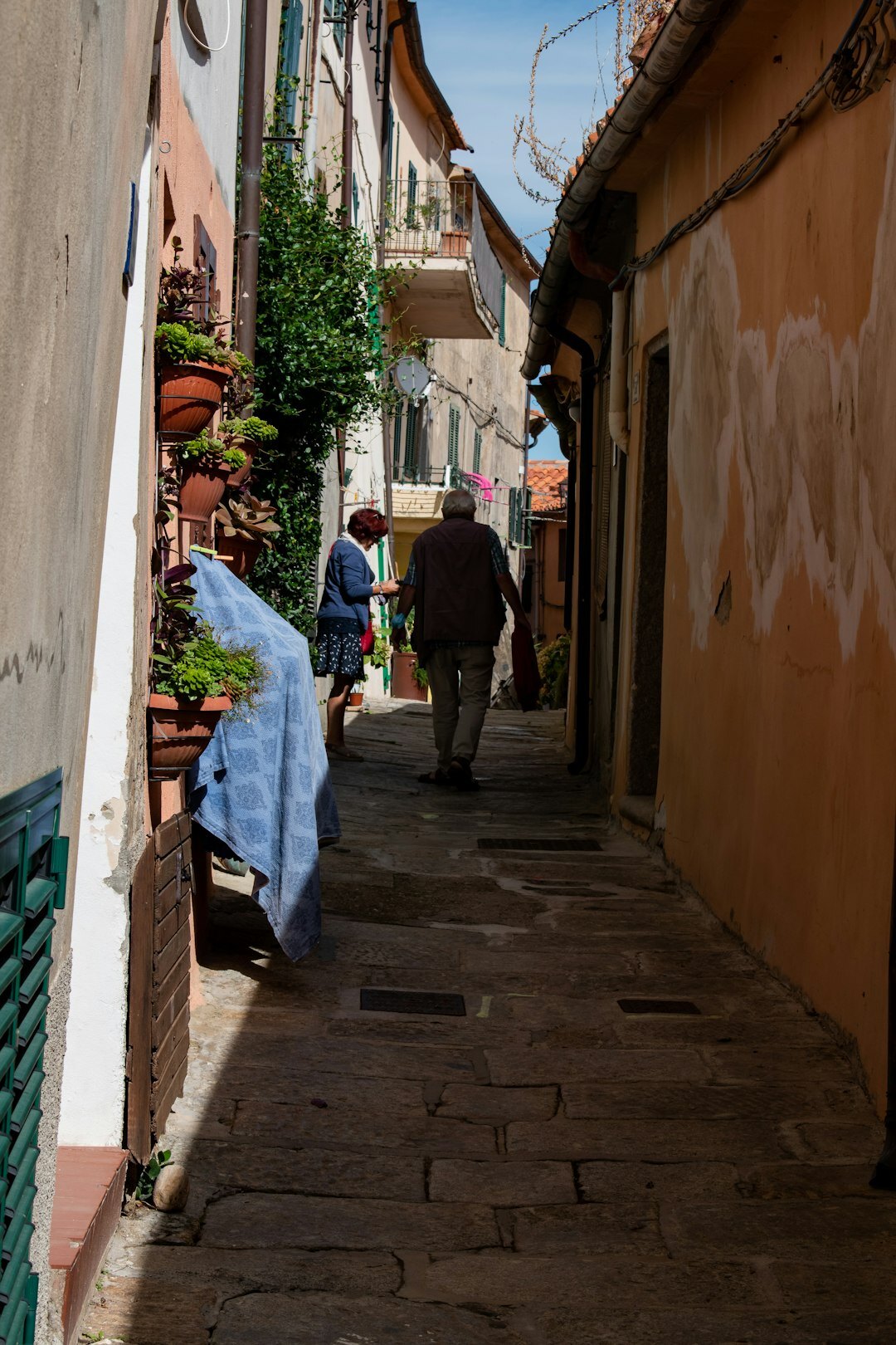 elderly couple walking in village street