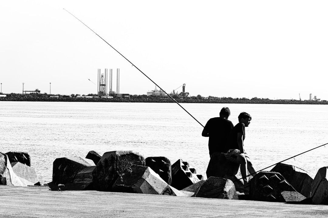 fisherman repairing nets on dock